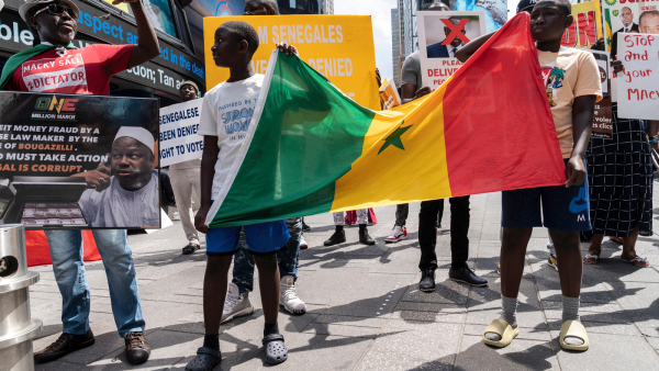 Protesters carry the Senegal flag
