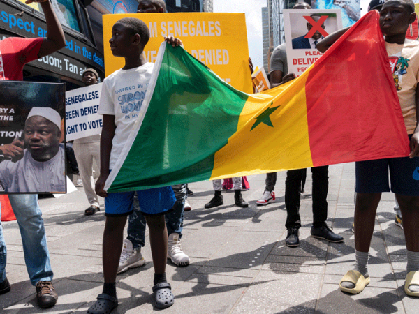 Protesters carry the flag of Senegal