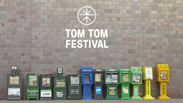 Lineup of newspaper boxes against a brick wall