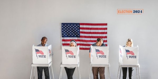 Four Americans standing at voting booths on Election Day