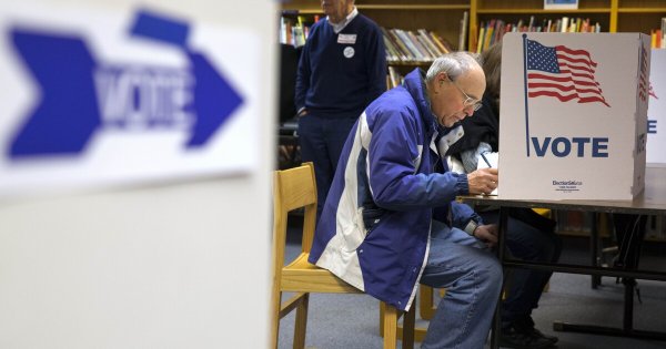 In this photo taken Nov. 5, 2013, Steve Maskell of McLean, Va., right, votes in an election.