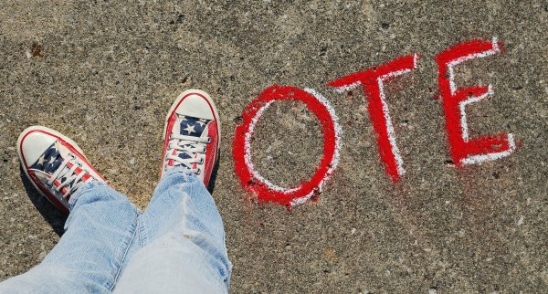 Photo of feet making the letter V in the word "vote"