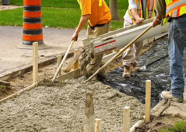 Construction workers smoothing concrete