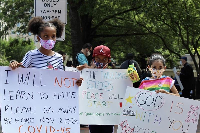 young protestors holding signs against hate