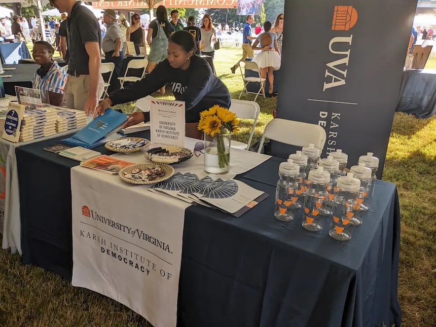 A student intern setting up the Karsh Institute booth at the Monticello July 4th event